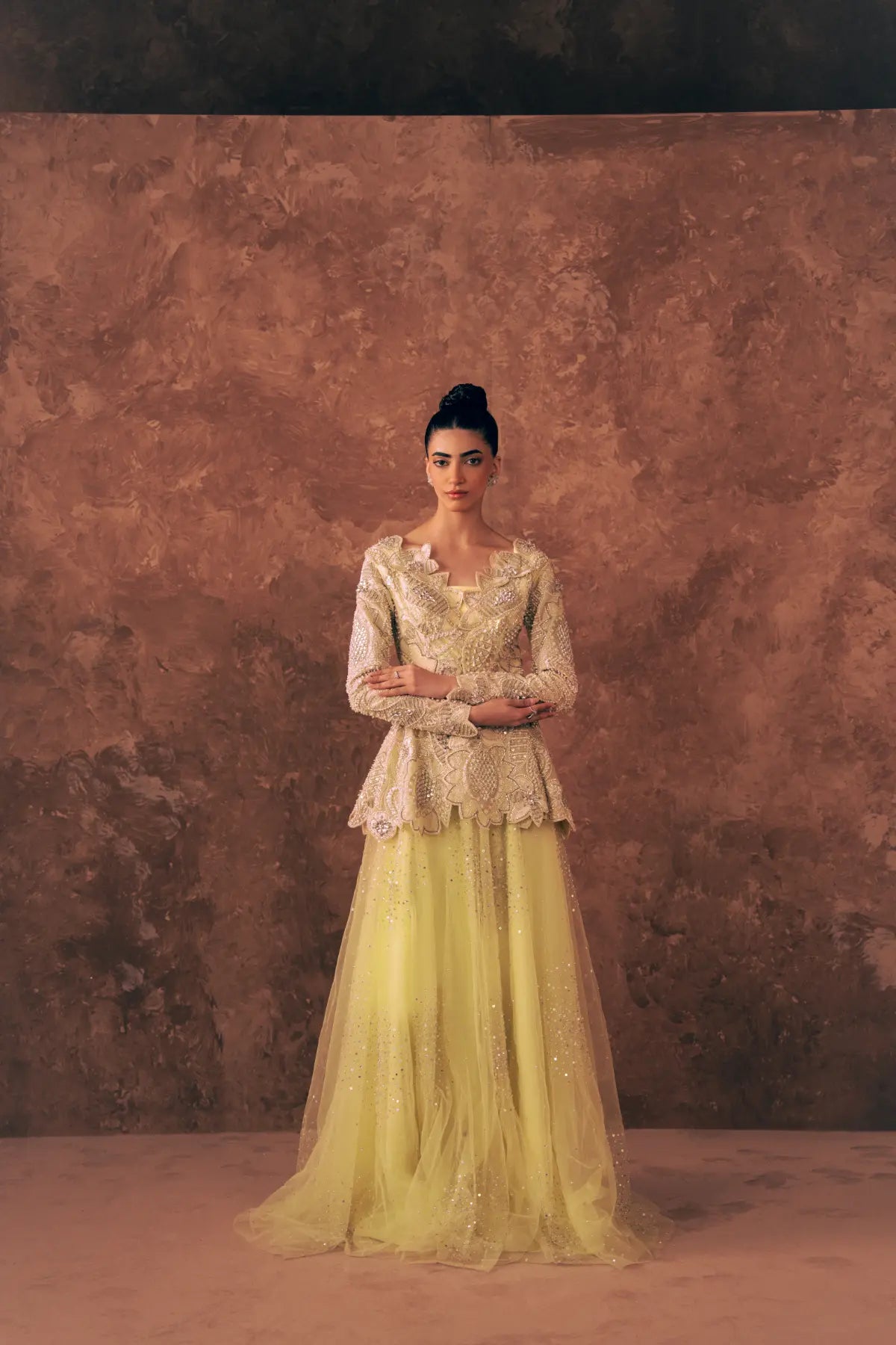 Model wearing Blooming Dawn lemon yellow Pakistani formal dress with embroidered long sleeve peplum and sequin net flared pants