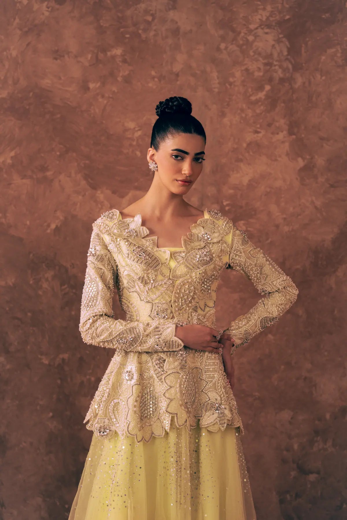 Model in Blooming Dawn organza peplum with long sleeves, pearl, crystal and zardozi embroidery over lemon yellow flared net pants
