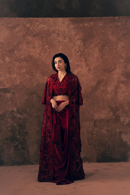 Crimson party wear dress with cutwork jacket and draped satin silk skirt featuring a beaded pocket with tassel fringe