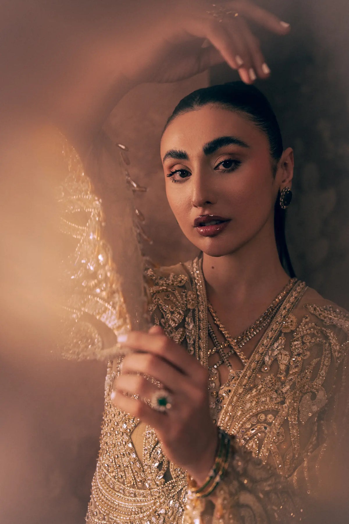 Close-up of criss-cross neckline and gold sequin, pearl and crystal embroidery on Ivory Opulence Pakistani formal dress