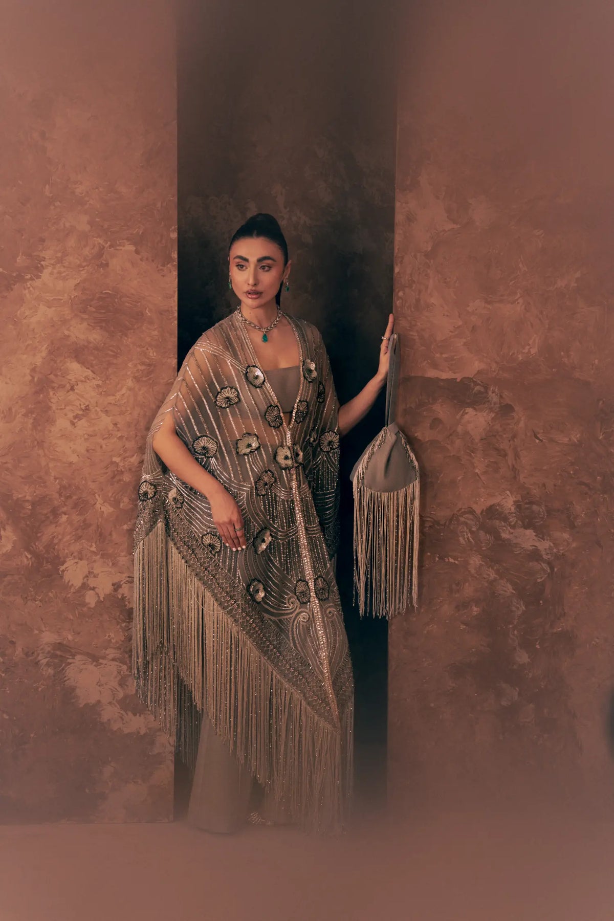Lunar Grace Pakistani formal wear with long tassel fringe cape and floral appliqué, styled with a fringed potli bag