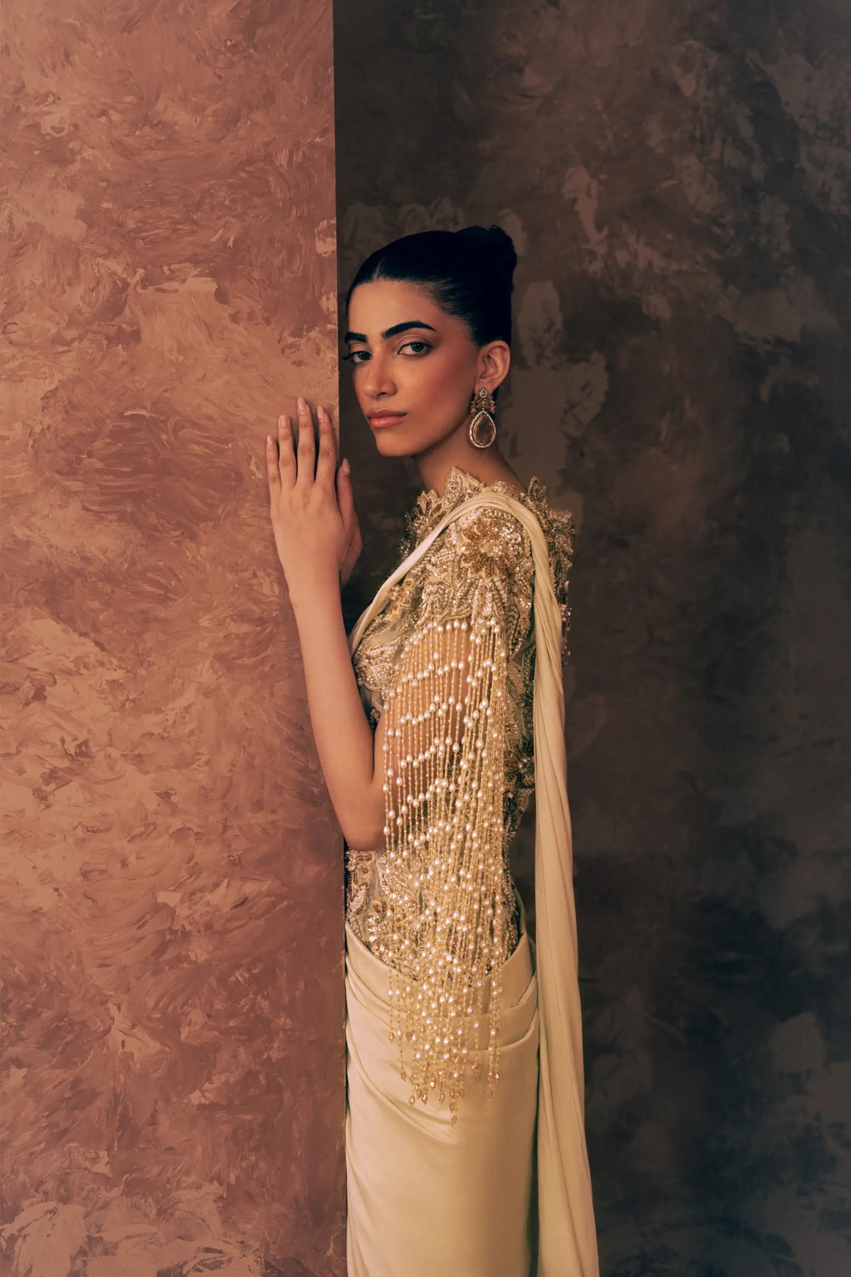 Side profile of Pearl Drapes formal dress showing pearl and crystal fringe sleeve, embroidered high neckline and satin silk drape