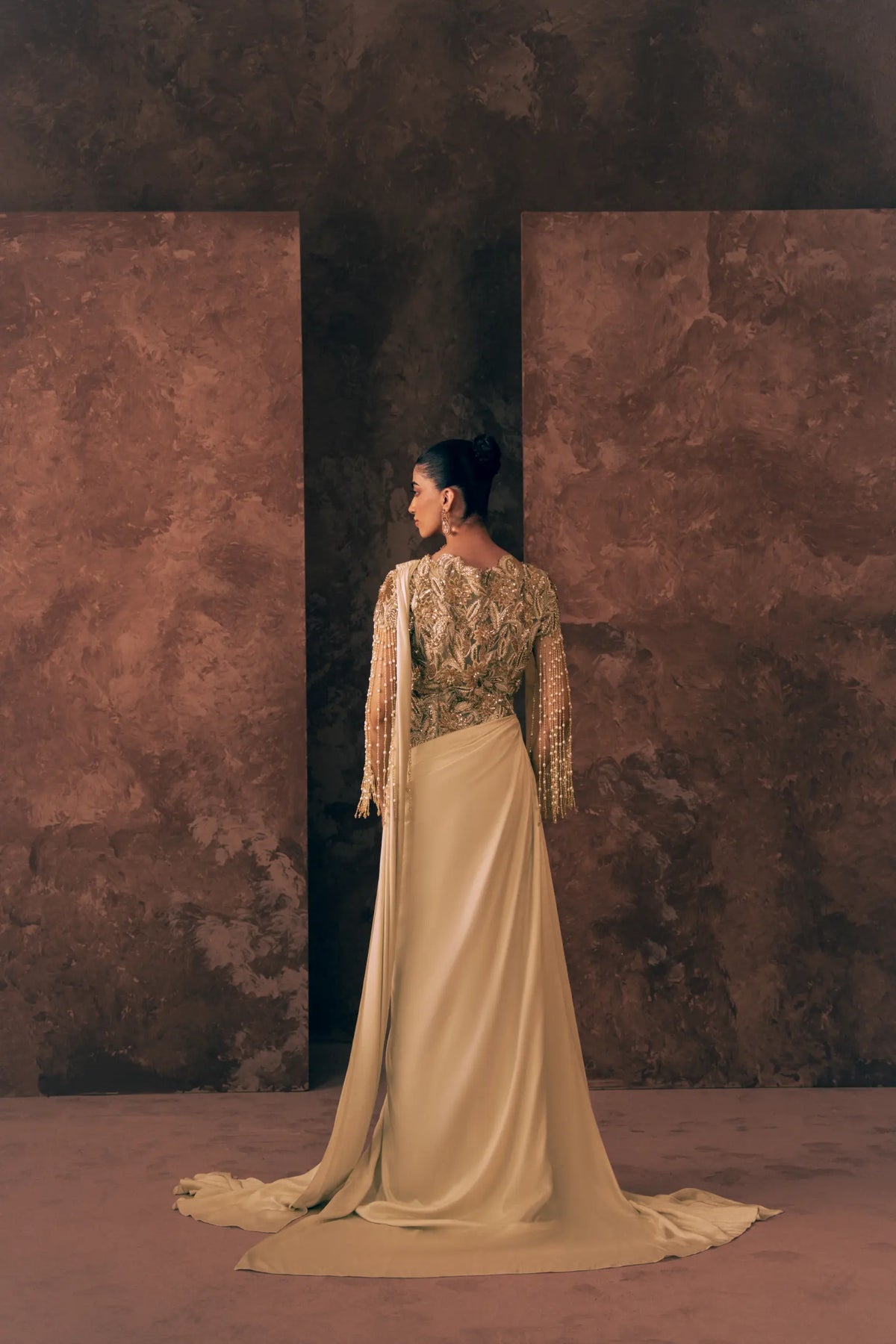 Back view of Vestis Pret Pearl Drapes 1 piece Pakistani formal dress showing embroidered net back, pearl tassel sleeves and long draped train